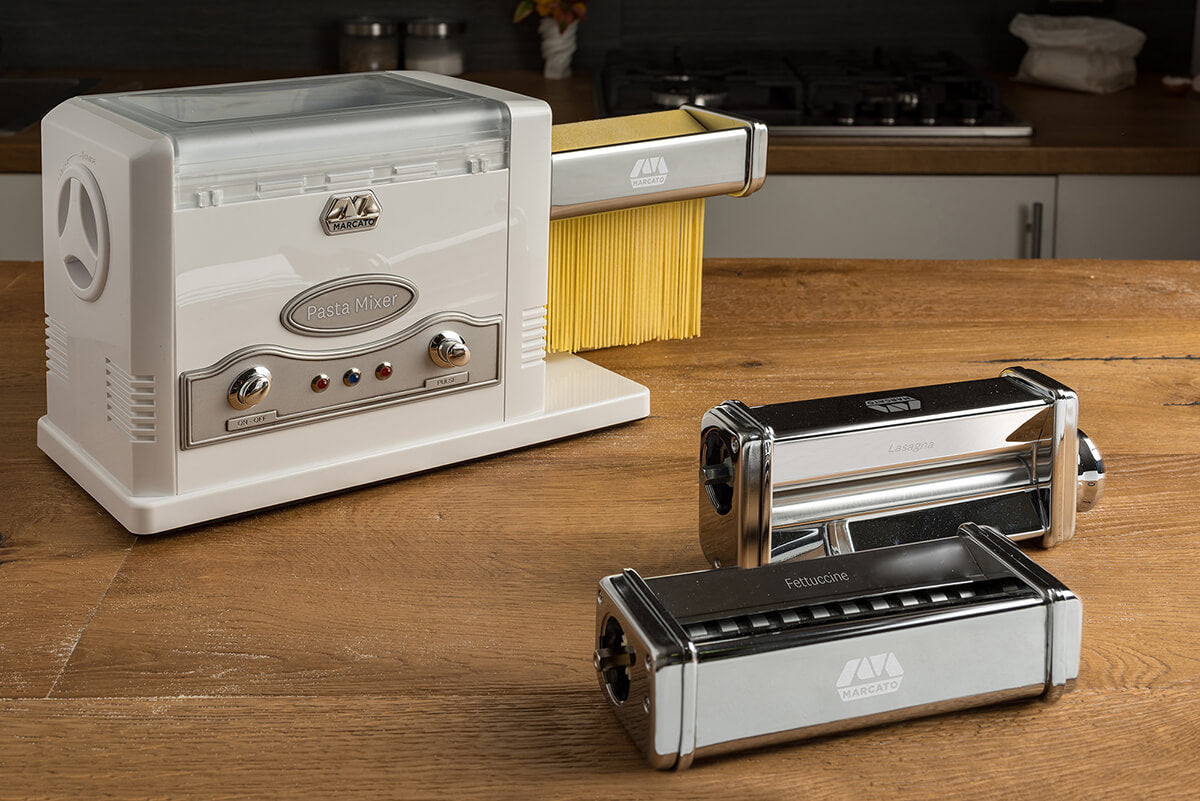 Pasta maker on a wooden surface with a kitchen background